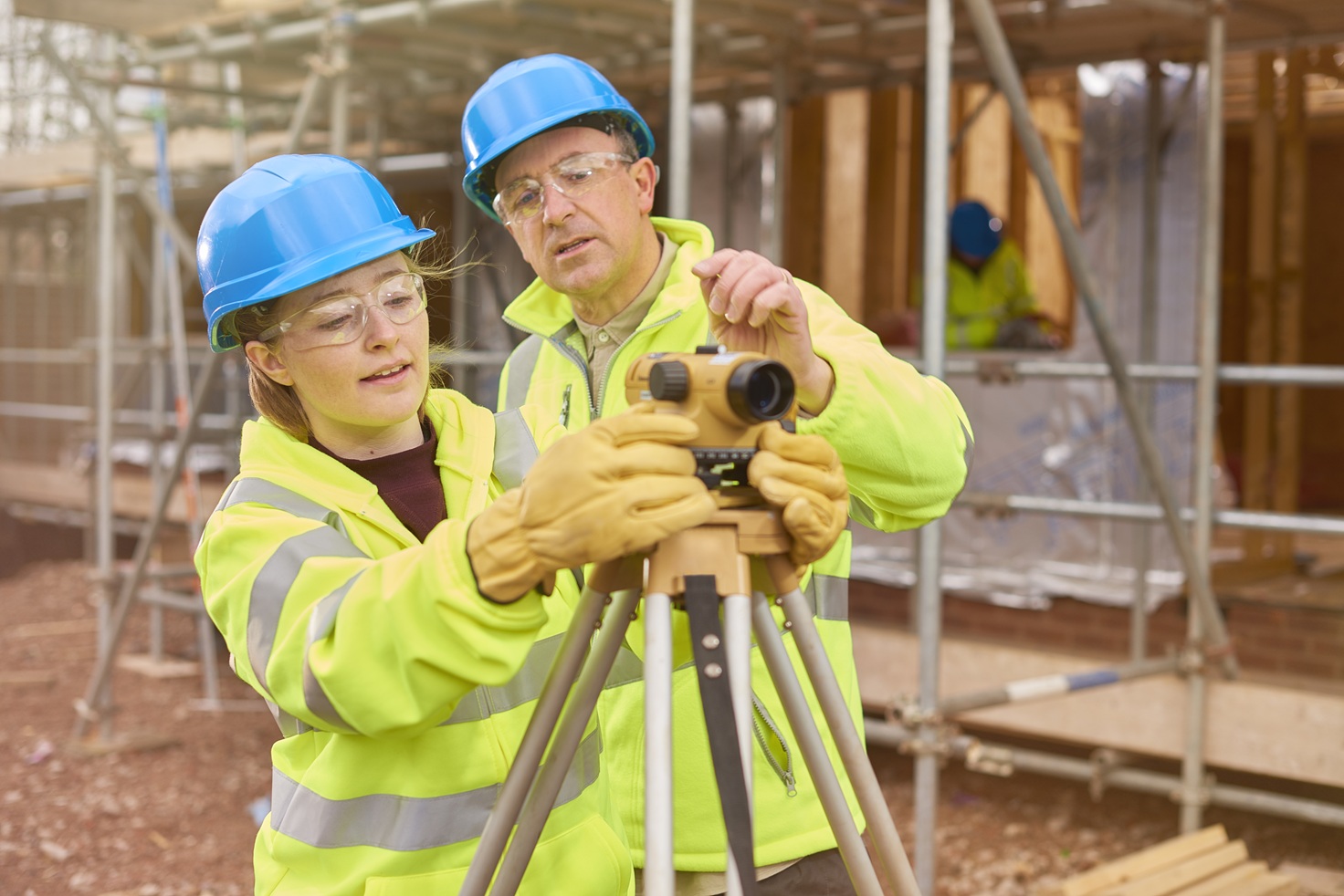 construction worker learning how to use a builder's level